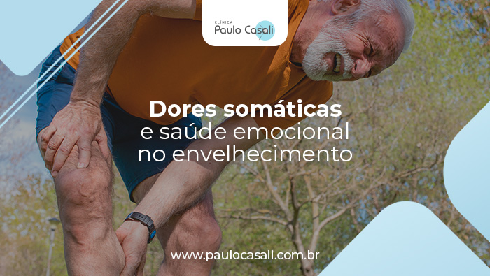 Homem idoso ao ar livre com expressão de dor, segurando a perna em sinal de desconforto muscular ou articular.