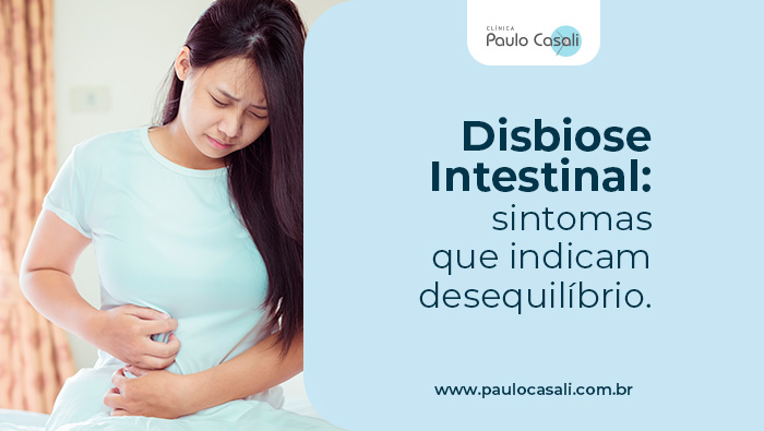 Disbiose Intestinal: sintomas que indicam desequilíbrio 1 Mulher com expressão de dor segura o abdômen, indicando desconforto intestinal ou dor abdominal.