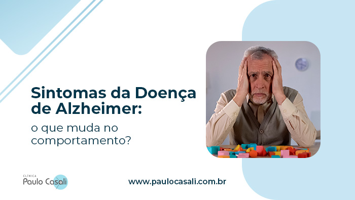 Sintomas da Doença de Alzheimer: o que muda no comportamento? 1 Idoso com expressão preocupada apoia a cabeça nas mãos, sentado à mesa com blocos coloridos espalhados à sua frente.