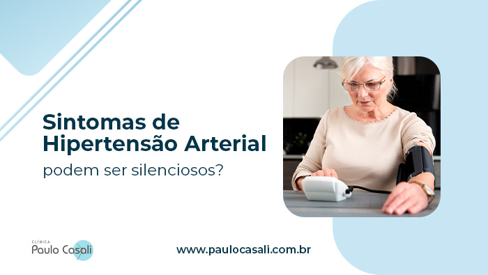Mulher idosa mede a pressão arterial em casa usando um aparelho digital no braço, observando atentamente o resultado.