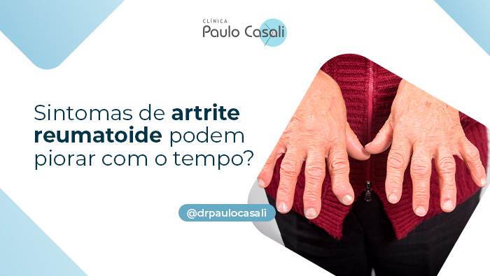 Mãos de pessoa idosa com deformidades nos dedos, vestindo casaco vermelho, sugerindo sinais de artrite reumatoide.